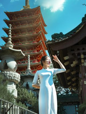 From below of beautiful young Japanese female in traditional white dress covering face by hand from bright sunlight while standing against amazing background of Sensoji temple ancient sculptures and cloudy blue sky